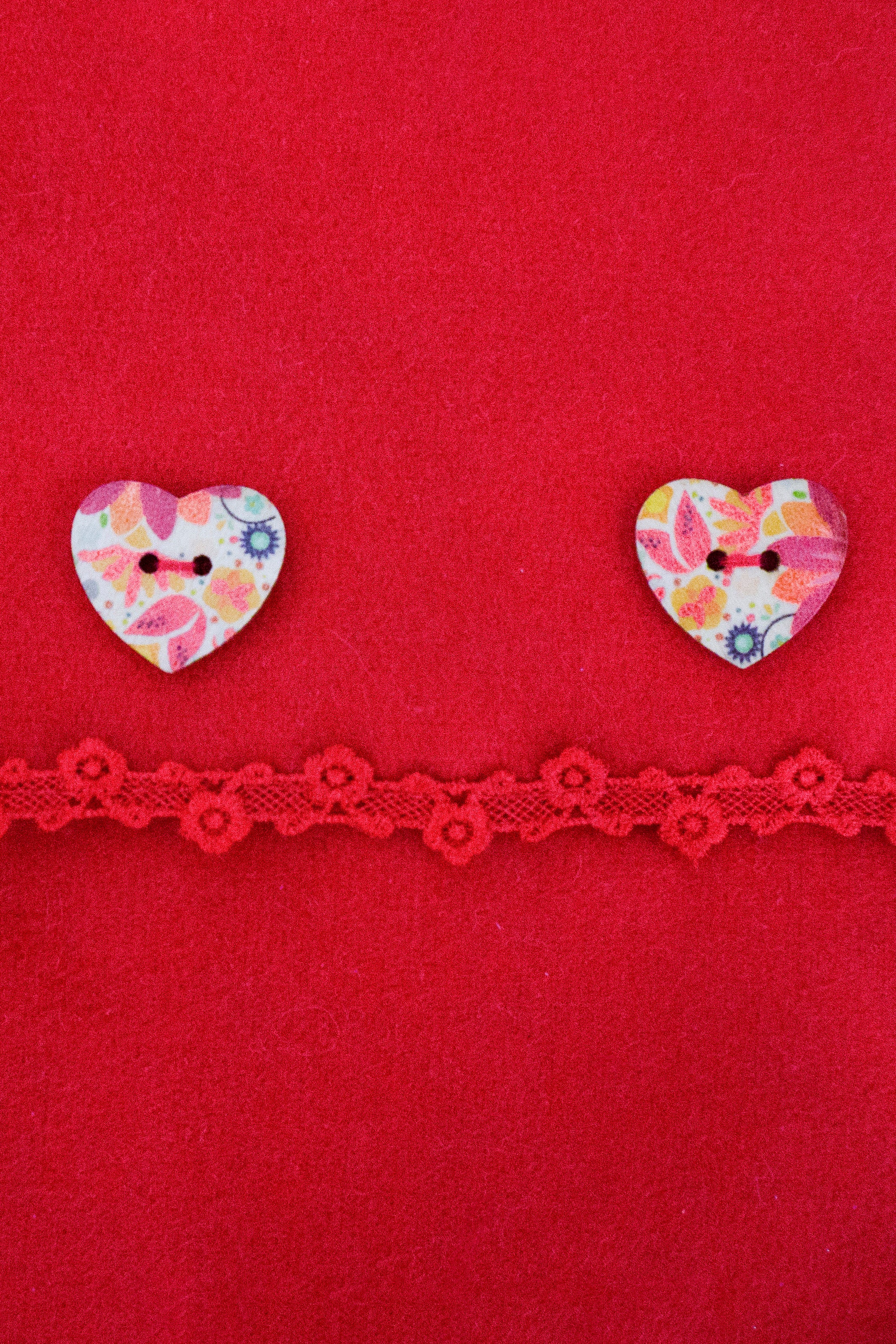 close up kids red poncho with heart buttons