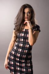 Short pink and black check dress in a photostudio