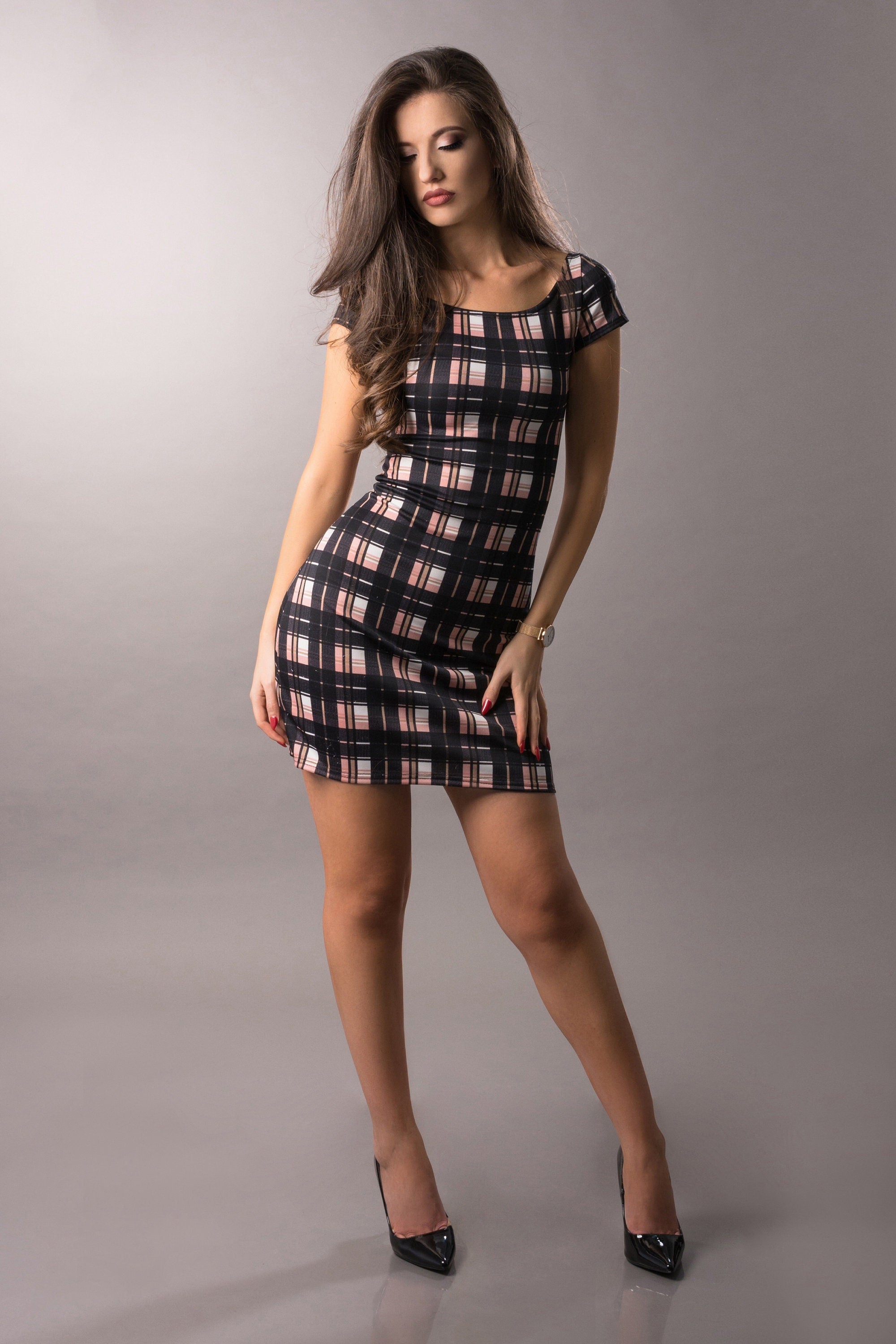 Woman with pink and black plaid dress in a photostudio