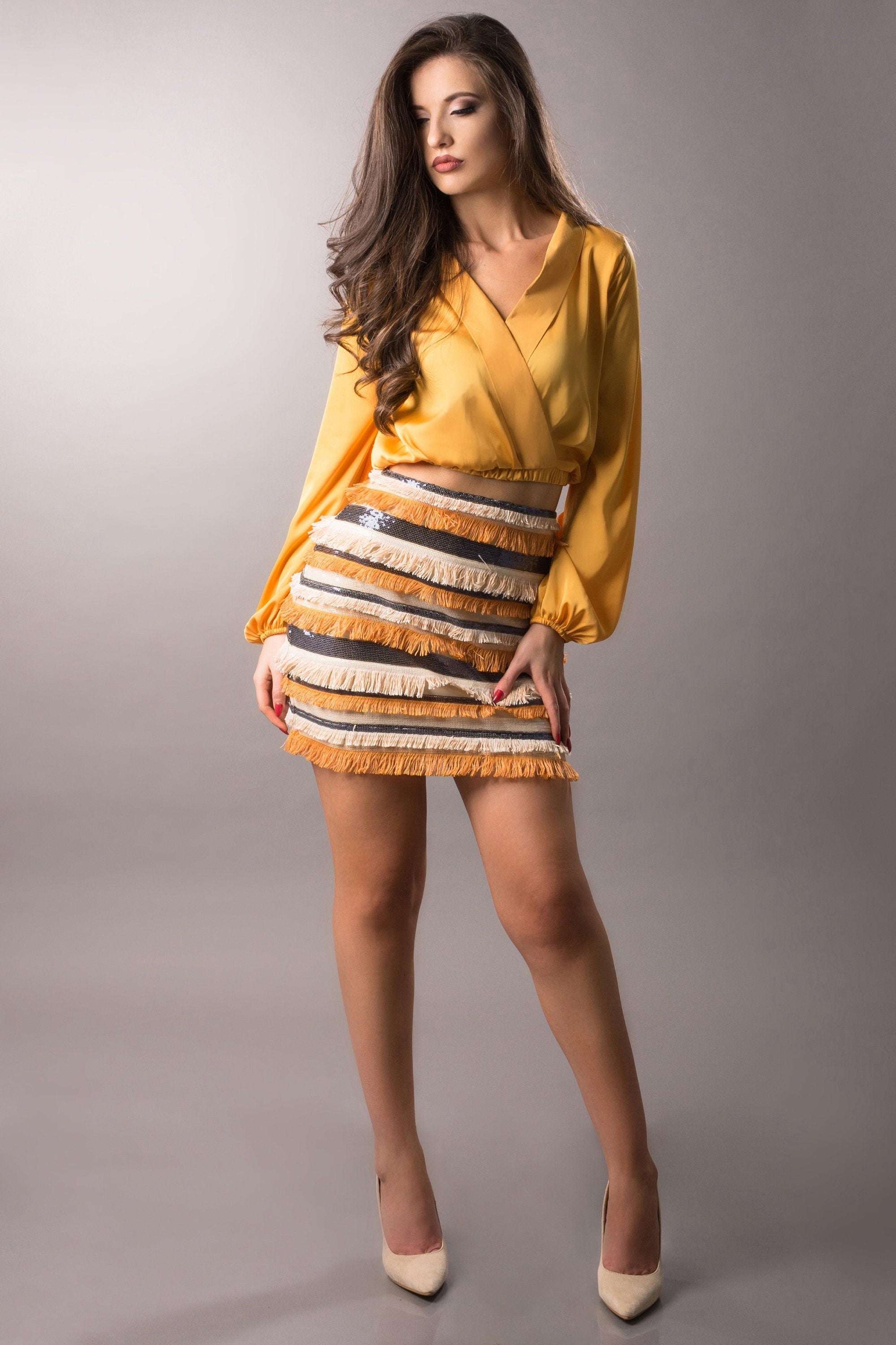 woman wearing high waist orange fringe/sequin skirt